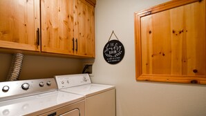 Une buanderie avec des armoires en bois, un lave-linge blanc et une pancarte sur laquelle on peut lire : « La buanderie ».