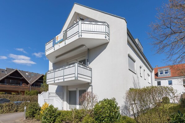 A modern two-story building with a balcony on the upper floor.