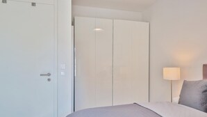 Une chambre d’hôtel avec un lit, une armoire et une lampe de chevet.