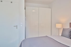 Une chambre d’hôtel avec un lit, une armoire et une lampe de chevet.