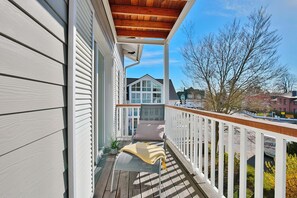 A wooden deck with a white railing, a bench, and a potted plant. - Haus Meeresbrise Appartement 19 (Haffkrug)