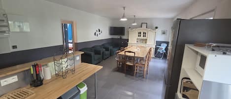 Een compacte keuken met een eethoek, een klein zithoekje en een kitchenette.