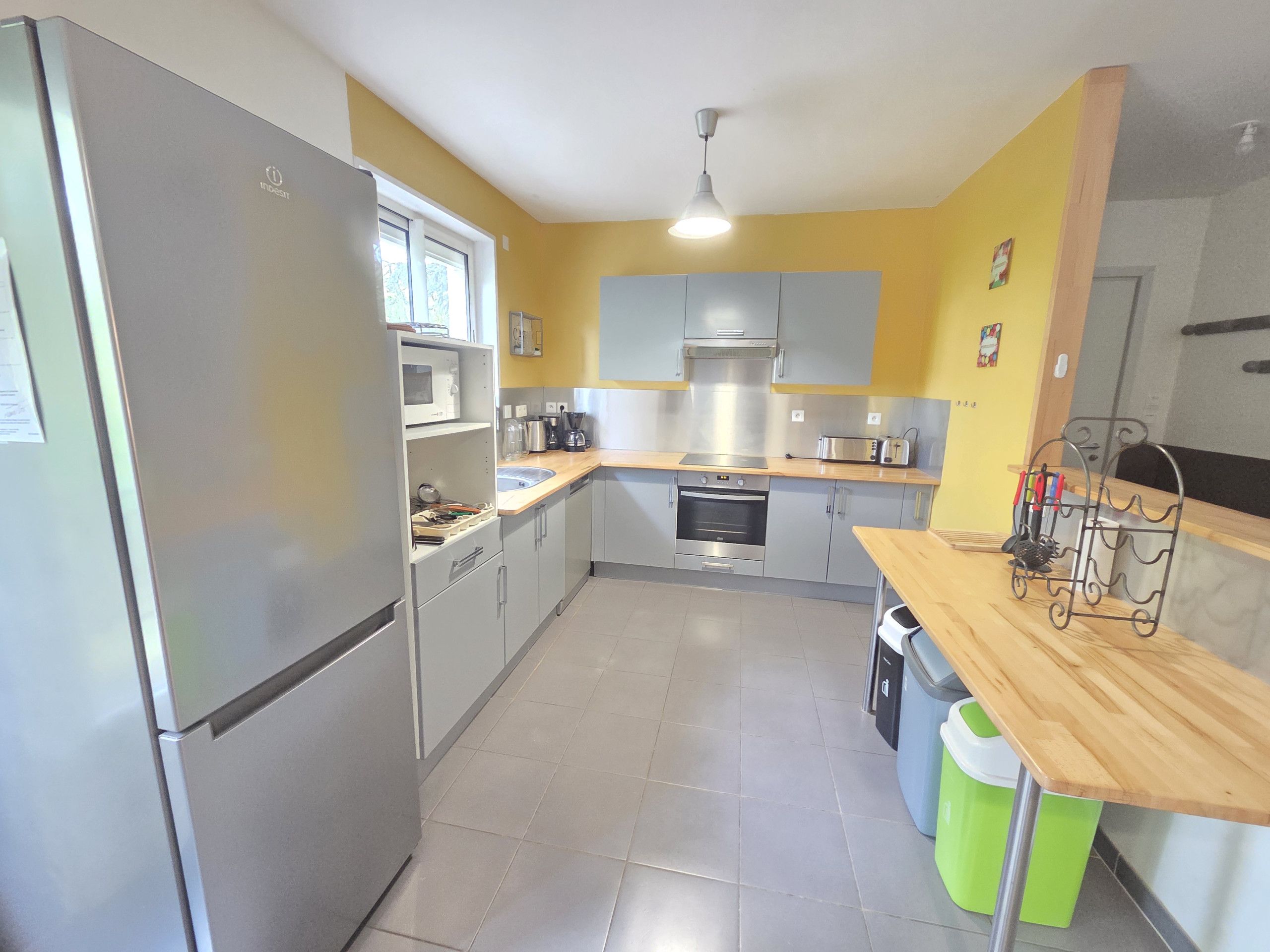 A compact kitchen with a refrigerator, oven, microwave, and a sink.