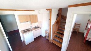 A compact kitchen with wooden cabinets, a built-in stove, and a sink. - 672P LMDS (Besse-et-Saint-Anastaise)