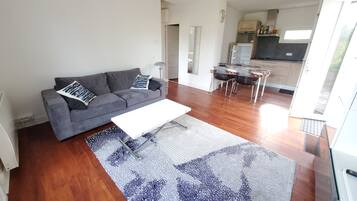 Relax in this open-plan living space with a sofa, coffee table, and dining area.