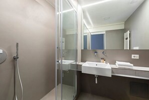 Apartamento Deluxe | Baño | Cabezal de ducha tipo lluvia y artículos de higiene personal gratuitos