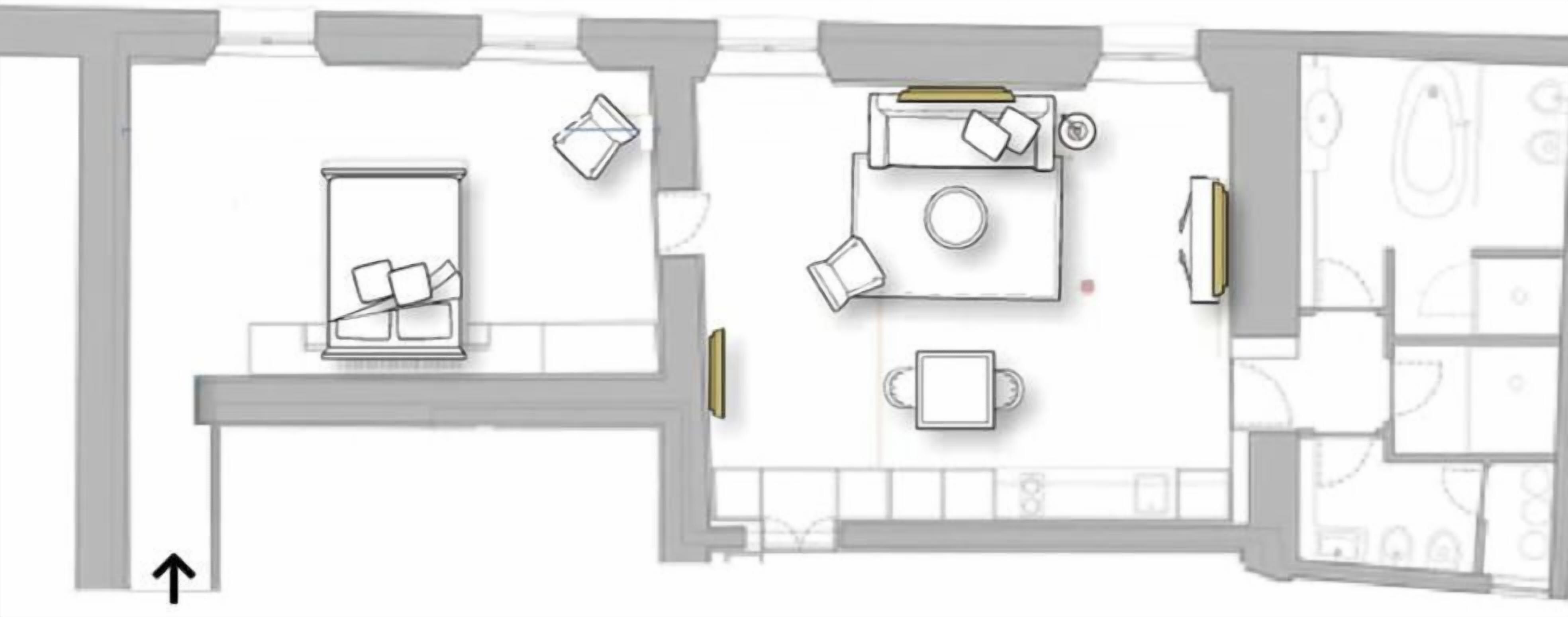 A floor plan of a hotel room with a bed, a desk, a chair, a small table, and a bathroom.