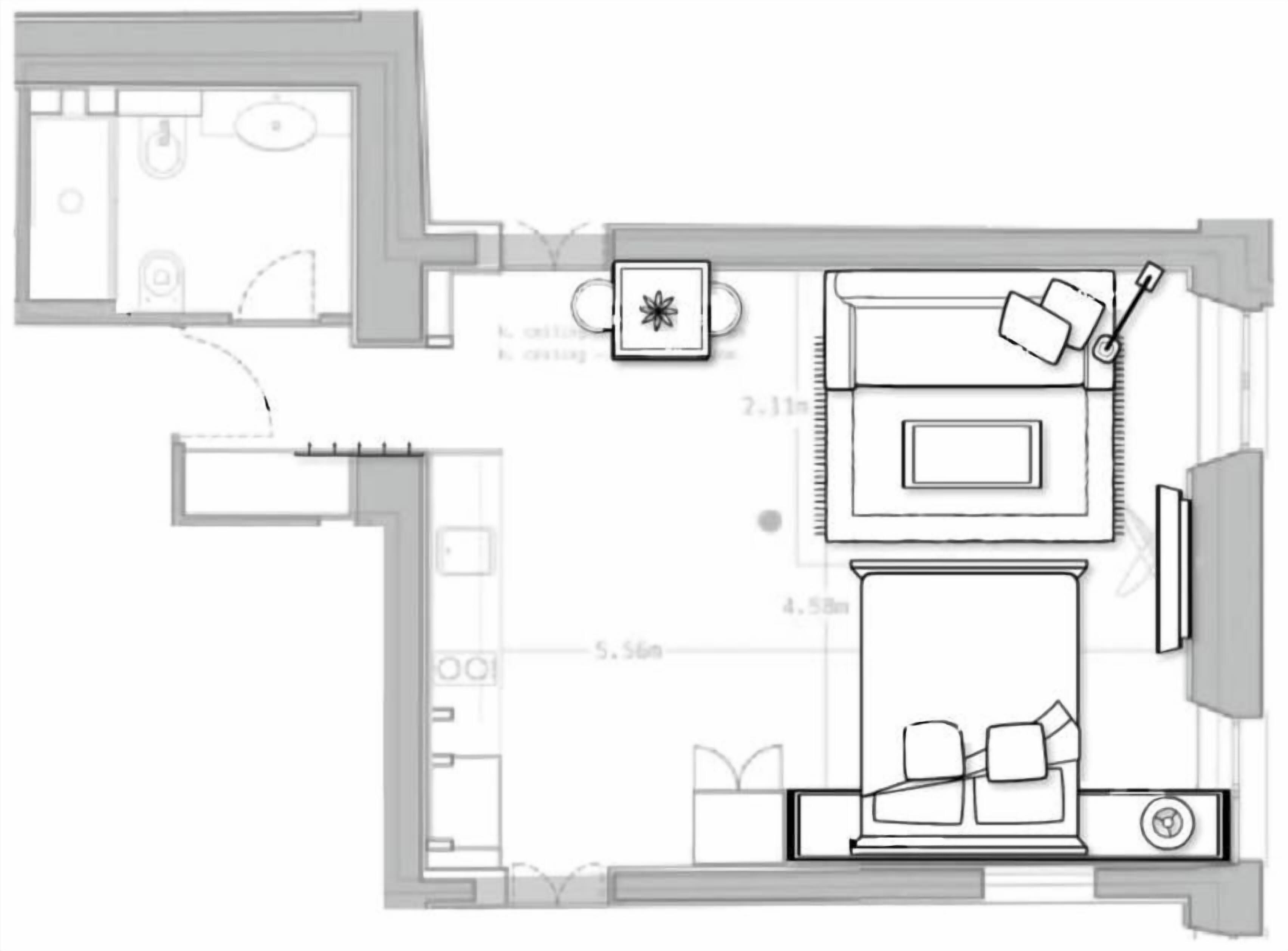 Een plattegrond van een hotelkamer, met een bed, een zithoek, een televisie en een kleine kitchenette.