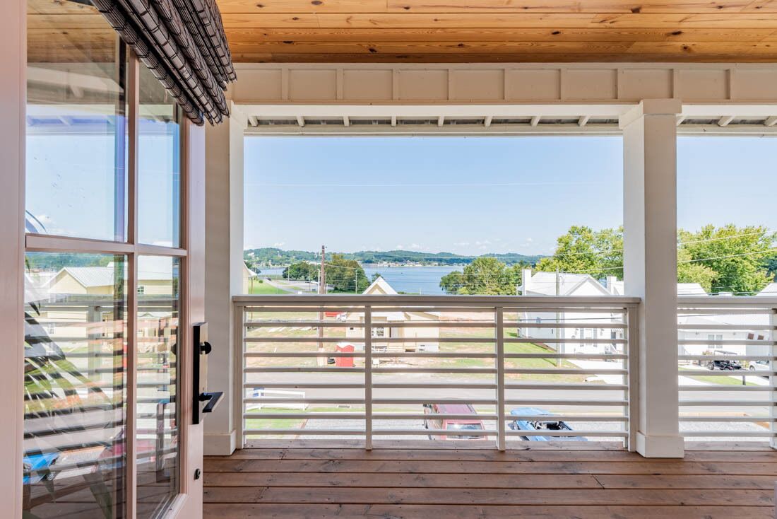 Un balcon avec vue sur un lac et des maisons.