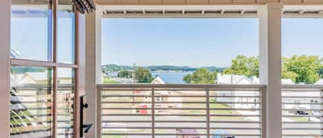 Un balcon avec vue sur un lac et des maisons.