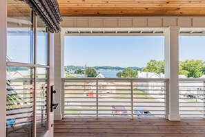 Un balcón con vista a un lago y casas.