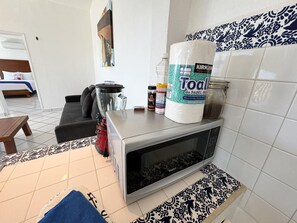 A kitchen with a microwave, a coffee maker, and a large bag of paper towels. - Hacienda + Condo 4: Oceanfront, Sleeps 18 (Aguacate)
