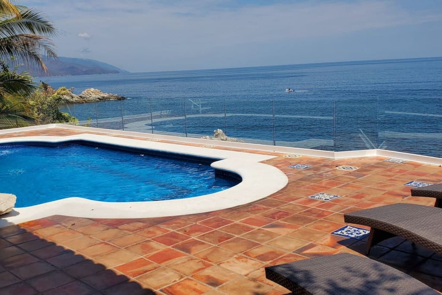 A swimming pool with a view of the sea and mountains.