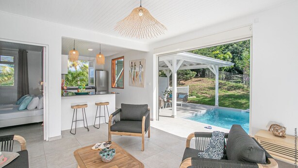 Sala de estar moderna com piscina, cozinha e área de estar com vista para o exterior.