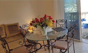 Relax in this inviting space with a glass-top table, comfortable chairs, and a wicker sofa.