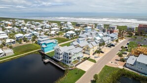 Una zona residencial costera con casas, un muelle y vistas al océano.