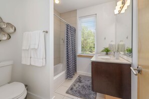 Bathtub, hair dryer, towels, shampoo