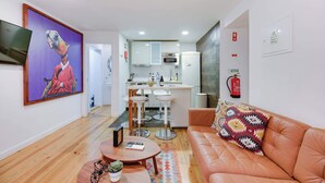 A modern living room with a sofa, a coffee table, and a painting on the wall.