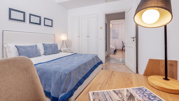 A bedroom with a bed, a desk, a lamp, and framed pictures on the wall. - L'Oiseau Bleu Marsa Plage  (La Marsa)