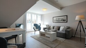A modern living room with a sofa, coffee table, and a lamp. - Domizil Gartenstraße 4 Appartement 7 Treibgut (Timmendorfer Strand)