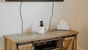 A wooden entertainment center with a flat-screen TV mounted above it.