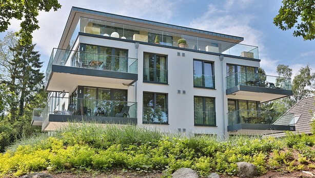 A modern multi-story house with large windows, balconies, and a well-maintained garden. - Villa Stern Appartement 2 (Timmendorfer Strand)