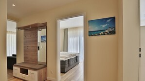 A modern bedroom with a large mirror, a bed, and a view of the sea through the window. - Villa Stern Appartement 2 (Timmendorfer Strand)