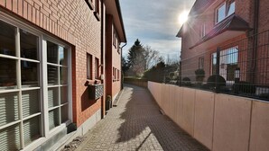 Ein Backsteinhaus mit großen Fenstern und einem gepflasterten Weg.
