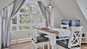 Ein Essbereich mit Tisch, Stühlen und einem Fernseher.
