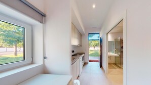 A modern kitchen with a large window, a built-in oven, and a sink.