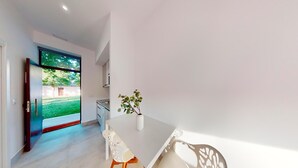 A modern kitchen with white cabinets and a large window. - One Bedroom Apartment (Toledo)