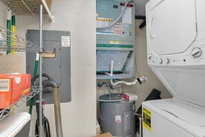 Ein Waschraum mit einer großen Industriereinigungsmaschine, einem Warmwasserbereiter und einer Filteranlage.