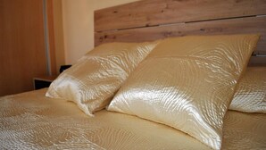 A bed with a wooden headboard and two pillows with a textured pattern.