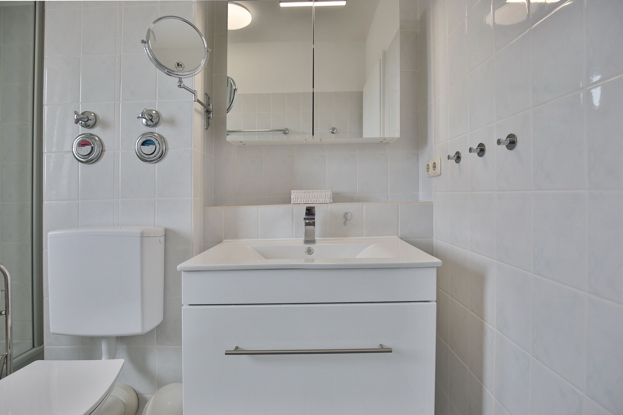 Une salle de bain moderne avec des toilettes, un lavabo et un miroir.