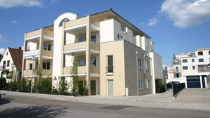 A multi-story residential building with balconies, a garage, and a clear sky. - Moderne Strandvilla Appartement 2 (Timmendorfer Strand)