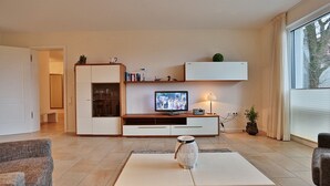 A modern living room with a flat-screen TV, a coffee table, and a sofa. - Villa Mér Baltique Appartement 20 (Timmendorfer Strand)