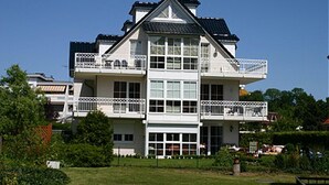 Ein zweistöckiges Gebäude mit Balkonen, großen Fenstern und einem flachen Dach.