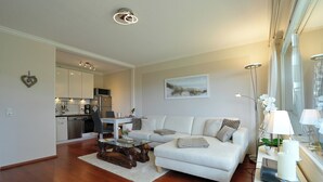 Una sala de estar moderna con un sofá, una mesa de centro y un comedor con sillas.