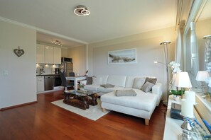 Un salon moderne comprenant un canapé, une table basse et un coin repas avec des chaises.