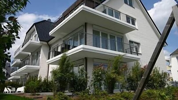 A modern multi-story residential building with balconies and a flat roof. - Die Wolburg Appartement 6 (Timmendorfer Strand)