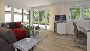 Un salon moderne avec un canapé, une table basse et un téléviseur.