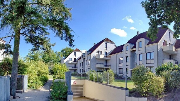 A residential complex with multiple apartment buildings, a gated entrance, and a well-maintained garden area. - Haus Kastanienallee 3 Appartement 6 (Timmendorfer Strand)