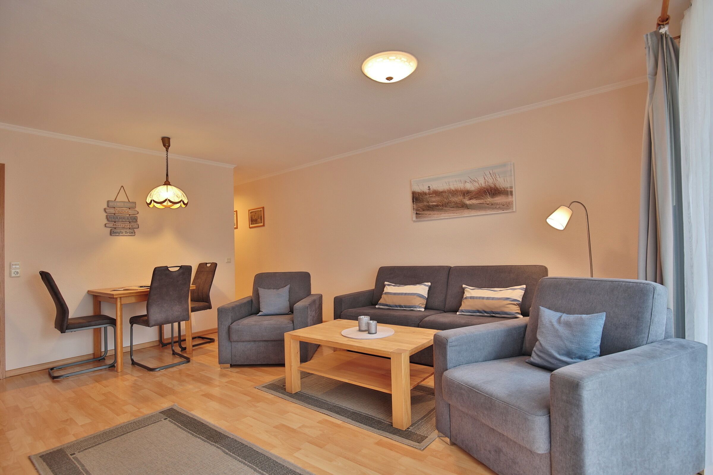 A modern living room with a sofa, two armchairs, a coffee table, and a dining table with chairs.