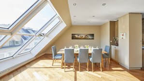 A dining area with a high ceiling, skylight, and a view of the cityscape. - Your rooftop penthouse in Vienna 2 (Wien)