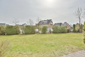 Un quartier résidentiel avec des maisons, une pelouse verdoyante et un chemin pavé.