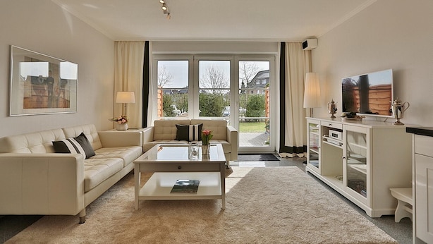 Un salon spacieux avec un canapé, une table basse et un téléviseur.