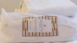 Una toalla blanca doblada con una etiqueta que dice 'ZEALOTS of nature'.