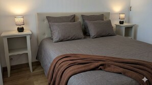 A bedroom with a bed, two bedside tables, and a nightstand. - Spacious quiet nest with garden near the sea (La Tranche-sur-Mer)