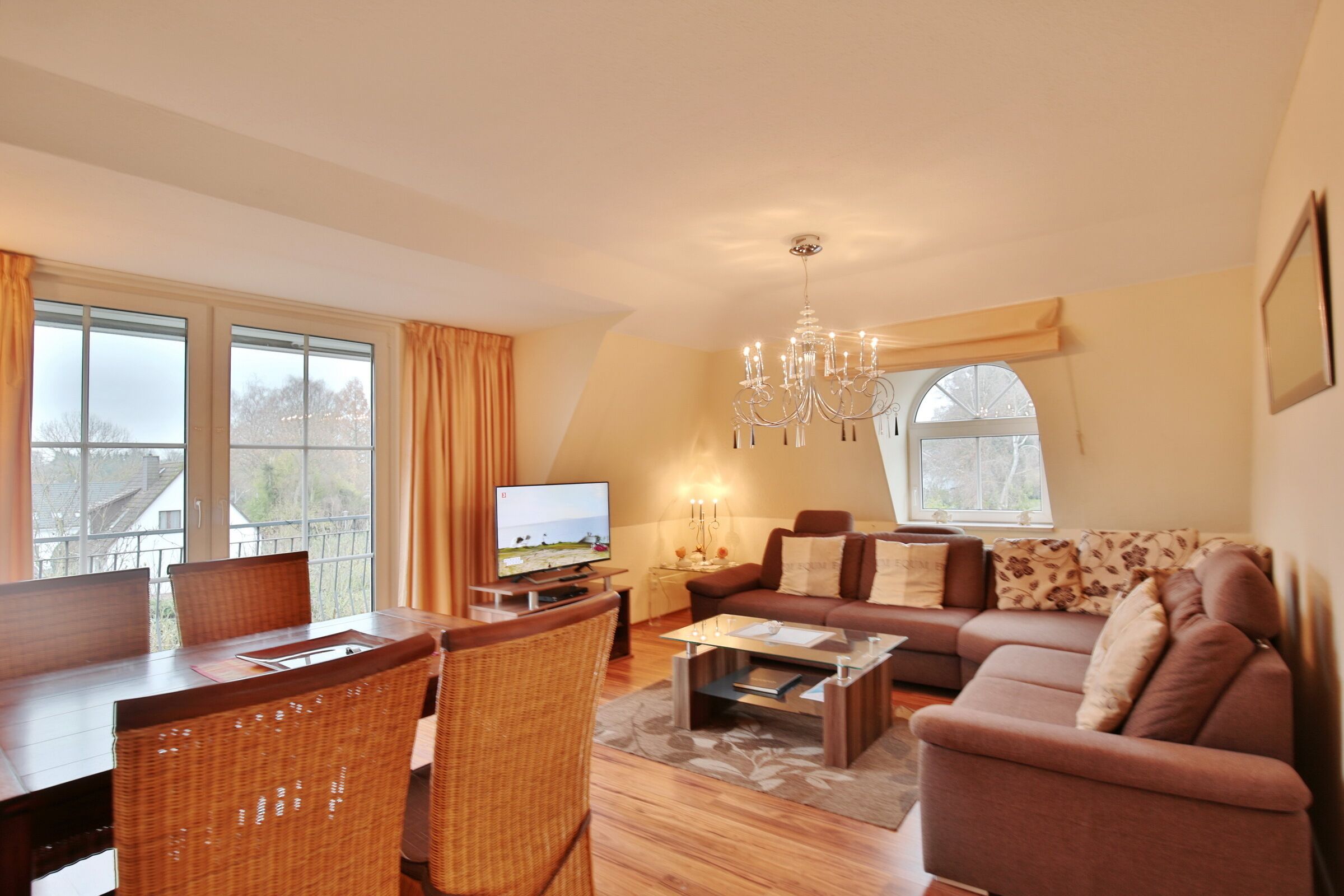 A living room with a dining table, chairs, a sofa, and a TV.