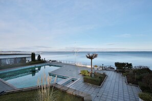 A rooftop swimming pool with a view of the sea, a flagpole, and a paved deck with seating. - Treffert Appartement 64 (Niendorf/Ostsee)
